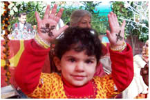 A beautiful child with her first henna mendhi designs.