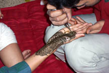 A mendhi wallah works on the hand of the bride.