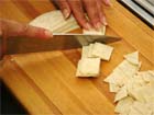 How to cut strips into cubes for making tortilla chips.
