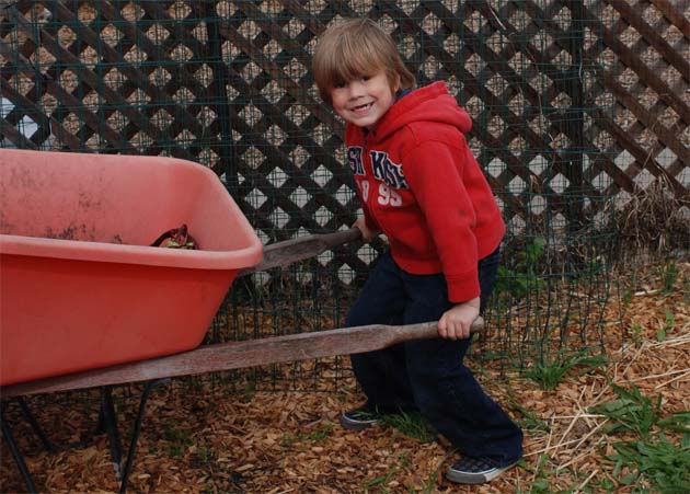 Sammy pushing the wheelbarrow in the enchanted garden.