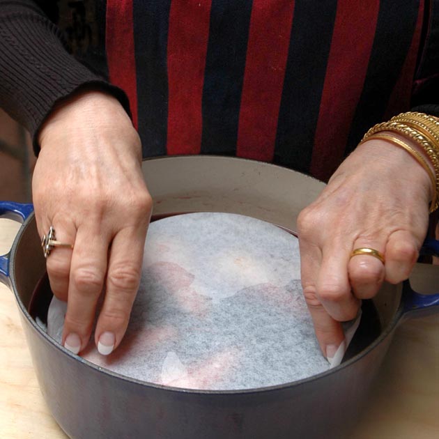 Parchment paper over pears for poaching.