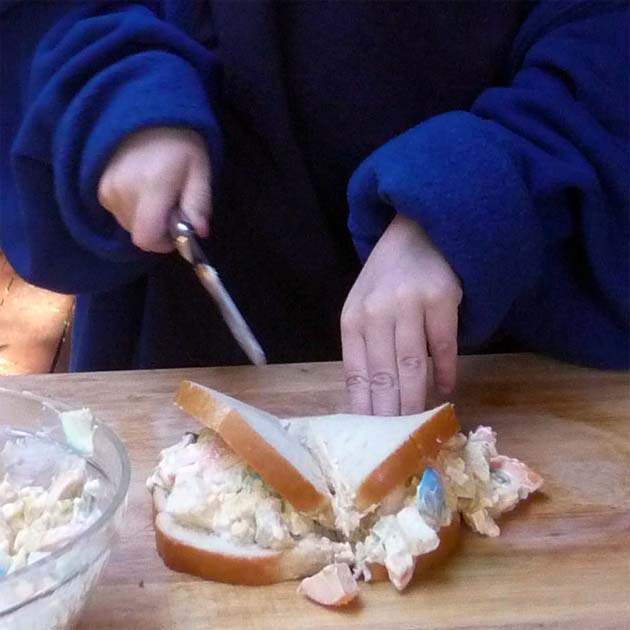 Cut egg salad sandwich in half.