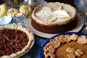 The dessert table set with the Vermont Pumpkin Maple Pie, Divine Maple Bourbon Pecan Pie, and the Pumpkin White Chocolate Cheesecake.